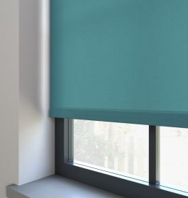 Our Burst Muted Teal dimout roller blind in a living room window.