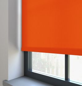 A orange dimout roller blind in a window