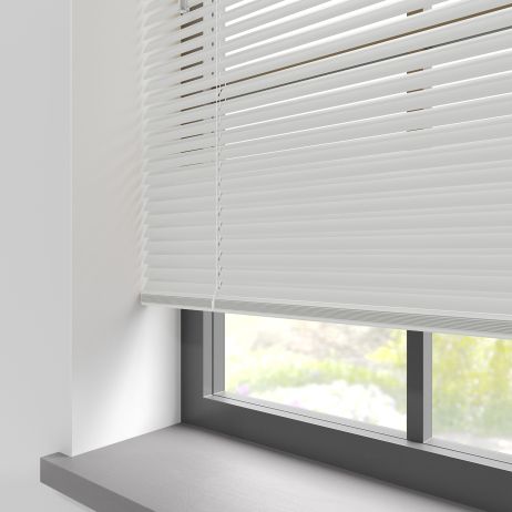 A white aluminium venetian blind in a window