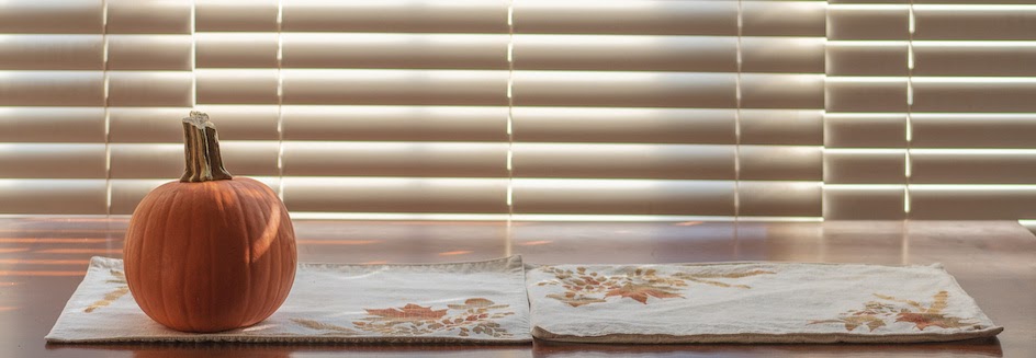 Faux wood blinds with a pumpkin and fall placemats in front