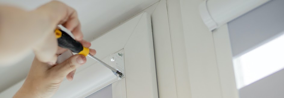 How to install blinds: Person screws in blind rail